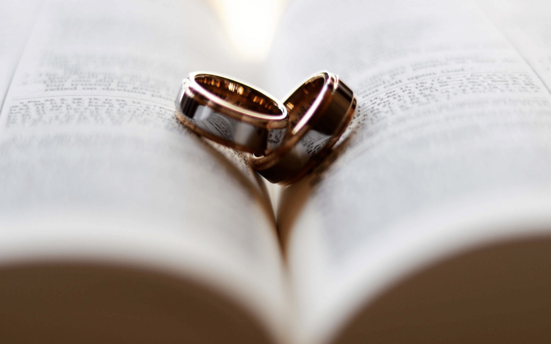 Two wedding rings resting on a book.